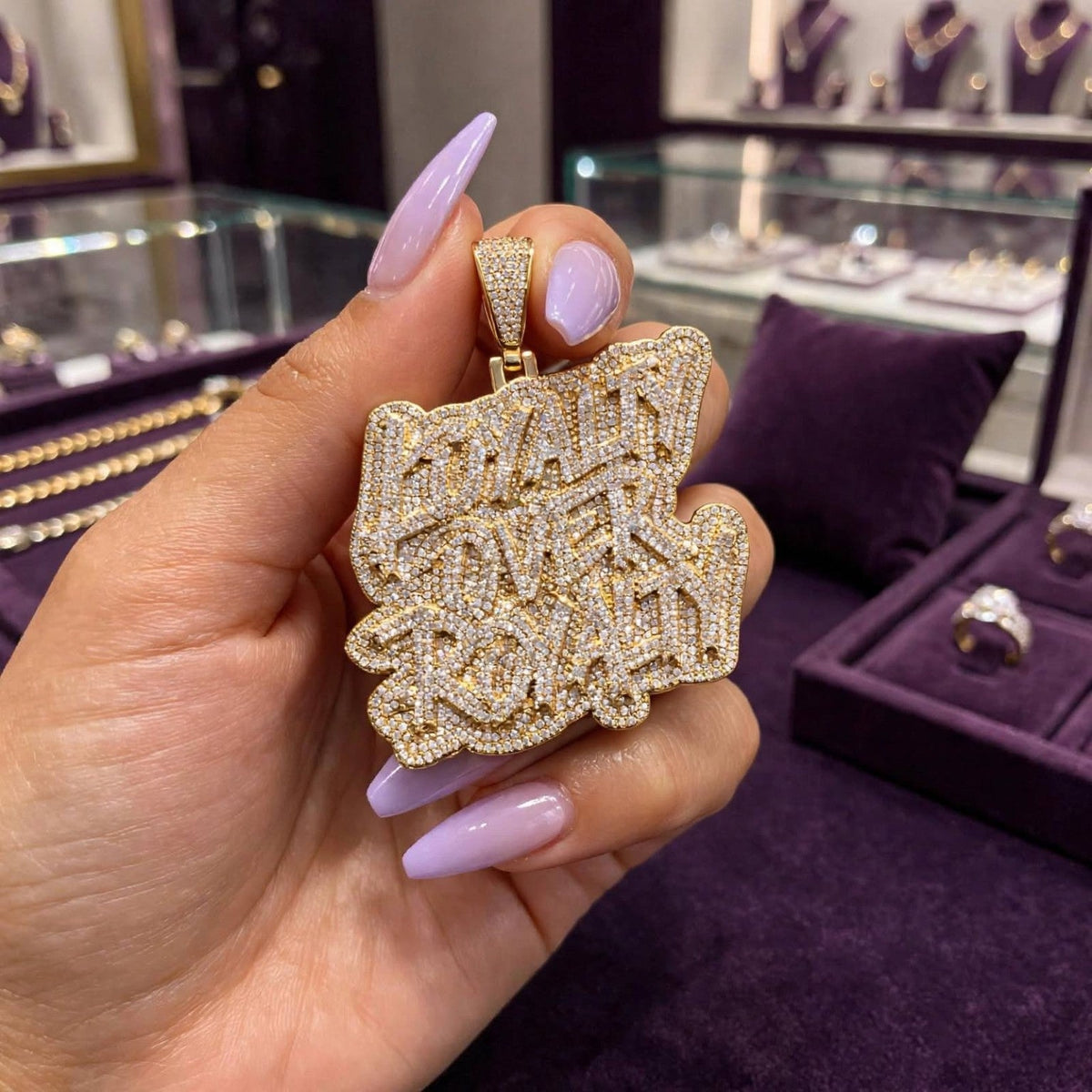 Loyalty Over Royalty gold-tone pendant close-up