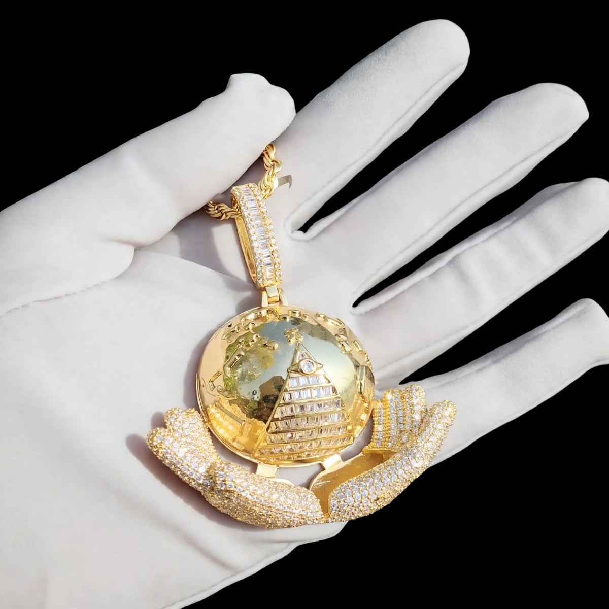 Gold The Architect pendant on a white glove