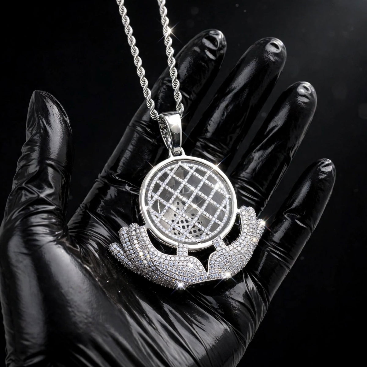 Silver The Architect pendant in a black-glove close-up