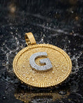 Gold G iced-out disc pendant with dramatic water splash