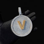 Silver iced-out disc pendant with gold V