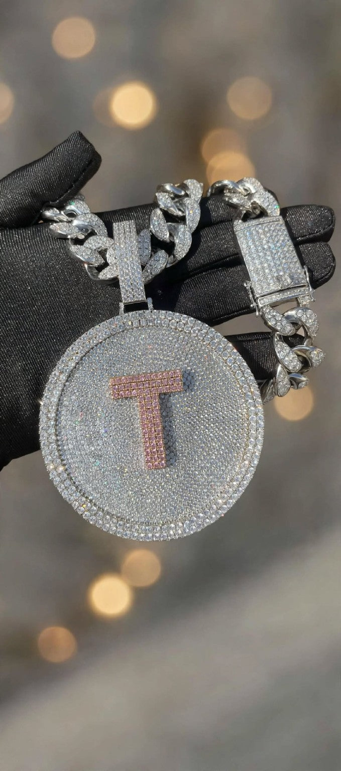 Silver iced-out disc pendant with pink T and Cuban chain