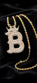 Gold crowned B initial pendant with rope chain on black velvet
