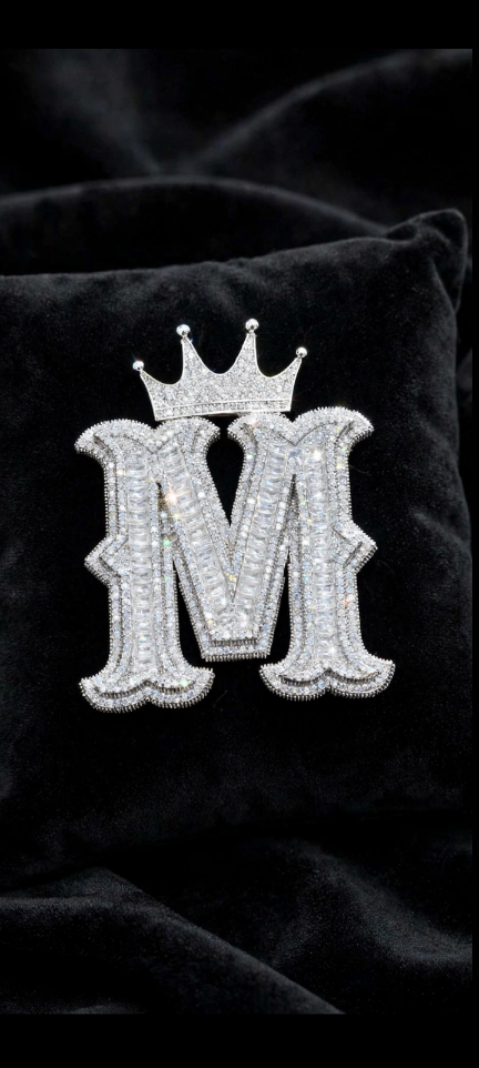Silver crowned M initial pendant on black velvet