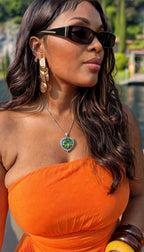 Green pendant worn with orange dress
