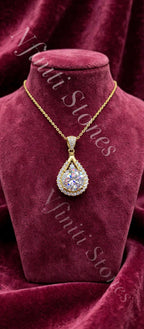 The Empress Teardrop necklace in gold finish on burgundy velvet
