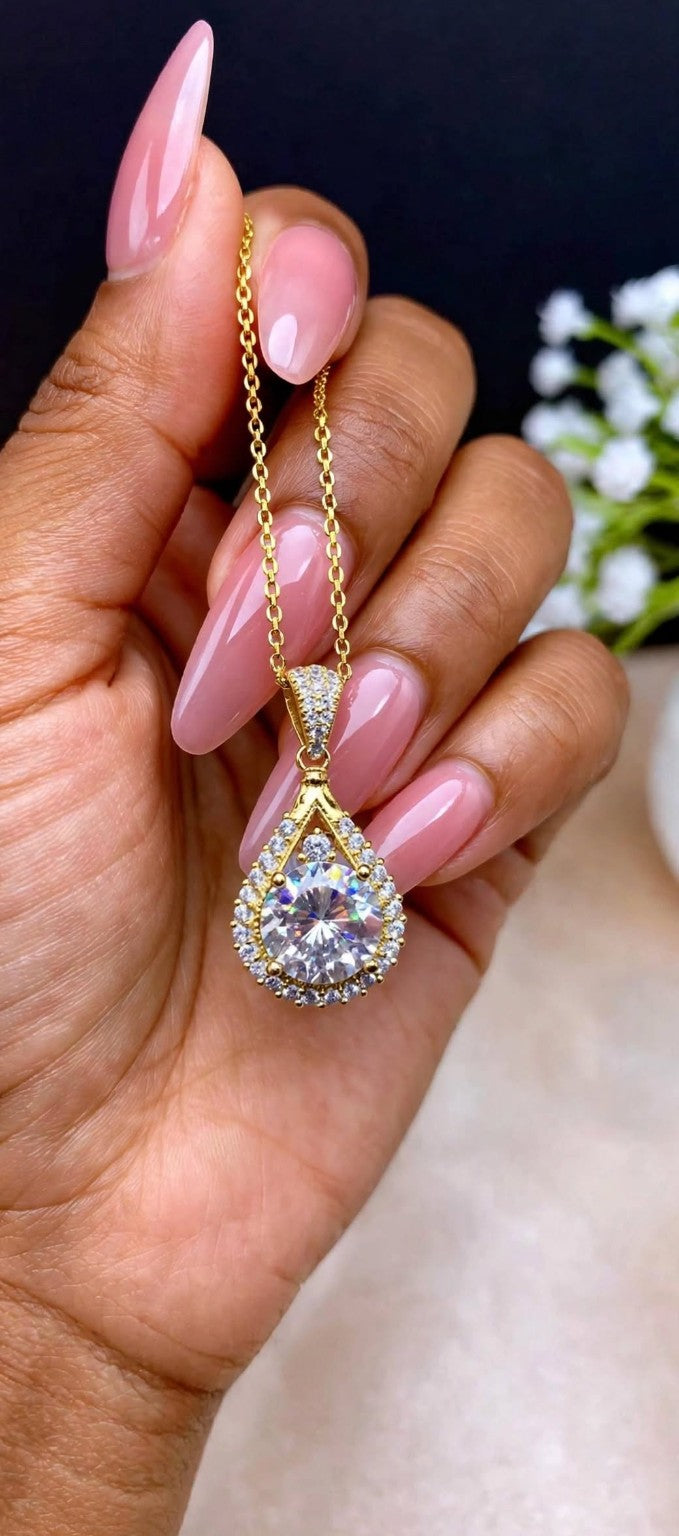 The Empress Teardrop necklace in gold finish held in hand