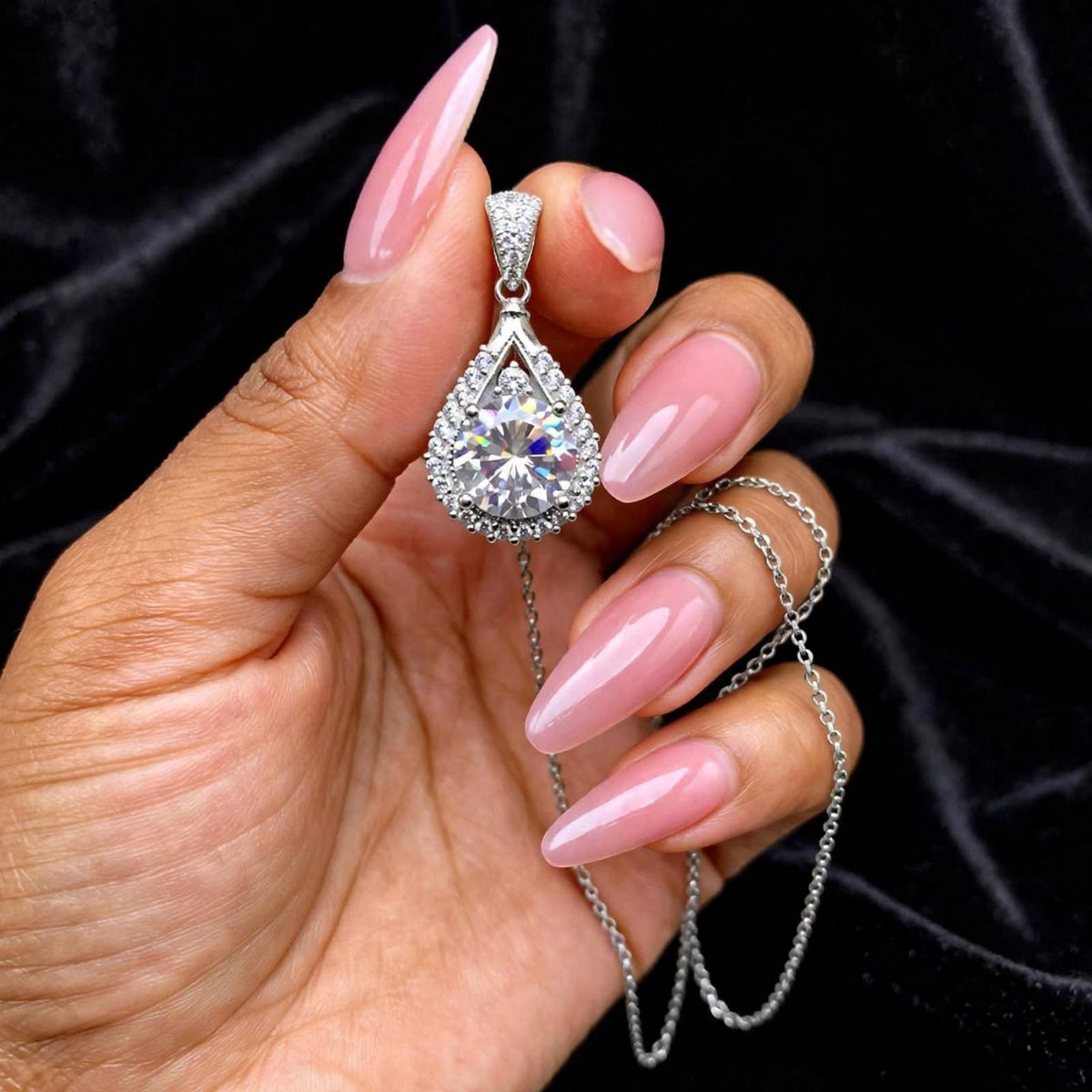 The Empress Teardrop necklace in white finish held in hand