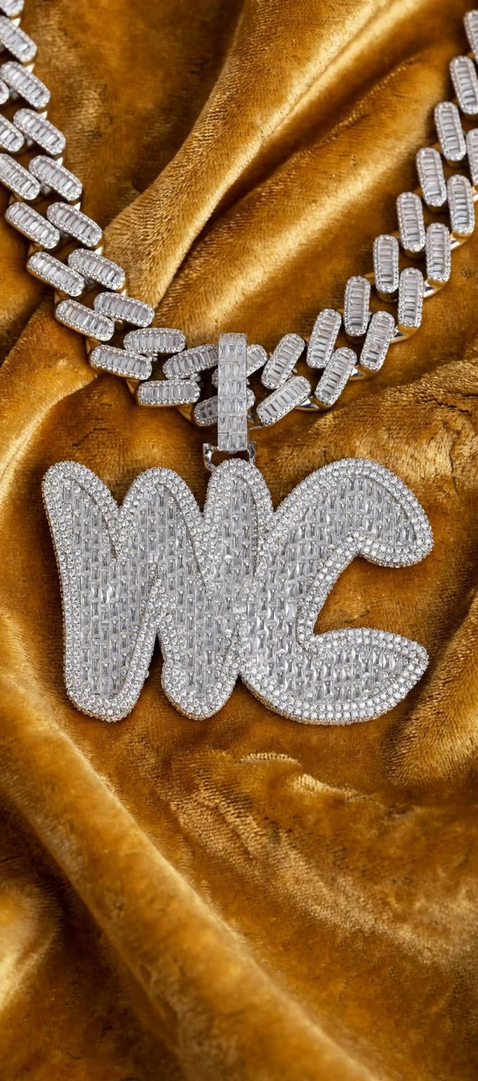 Close-up of personalized baguette stone pendant and chain on gold velvet