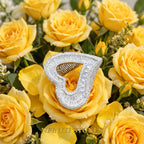 Silver finish iced open heart ring displayed on yellow roses