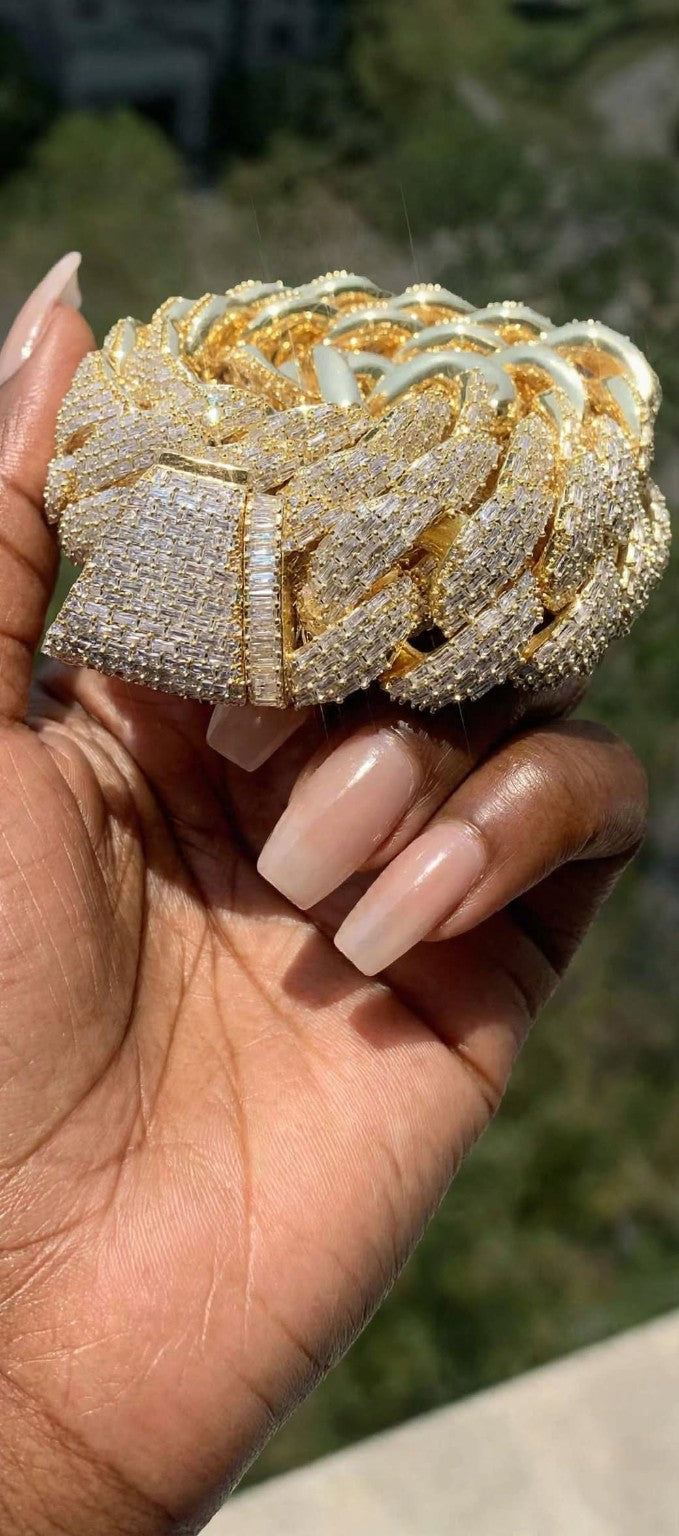 The Kingpin gold chain held in hand, close-up