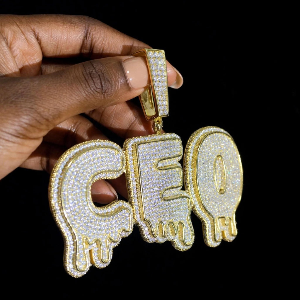 The Drip gold CEO pendant, angled side view showing iced bail and lettering