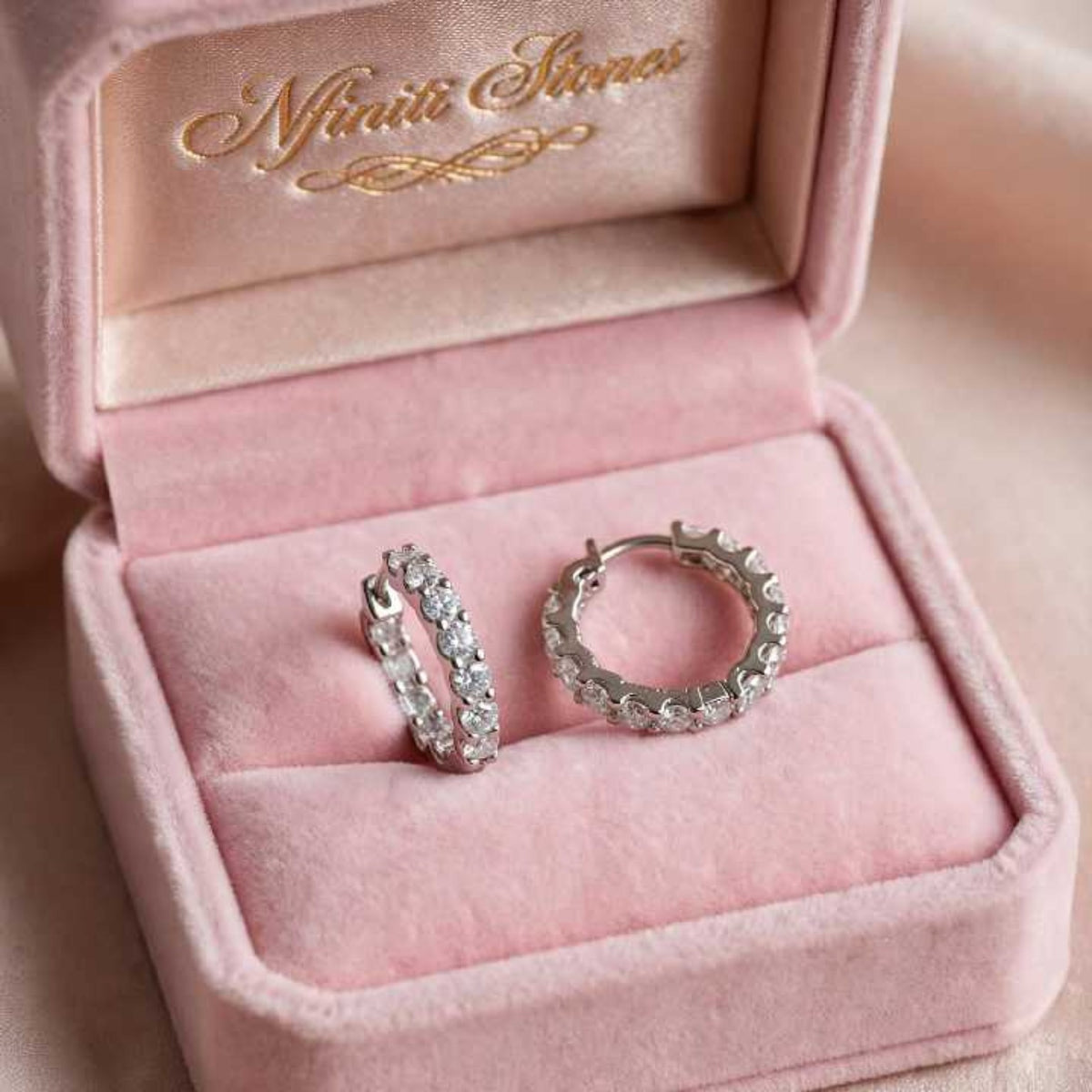 White finish Nfiniti Radiance moissanite hoops in a pink jewelry box