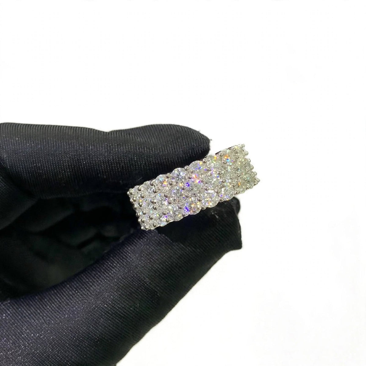 Close-up of three-row ring held in glove