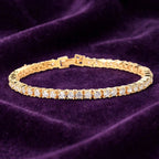 Gold tennis bracelet with open clasp on purple velvet