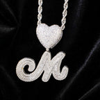 Silver M necklace on black velvet