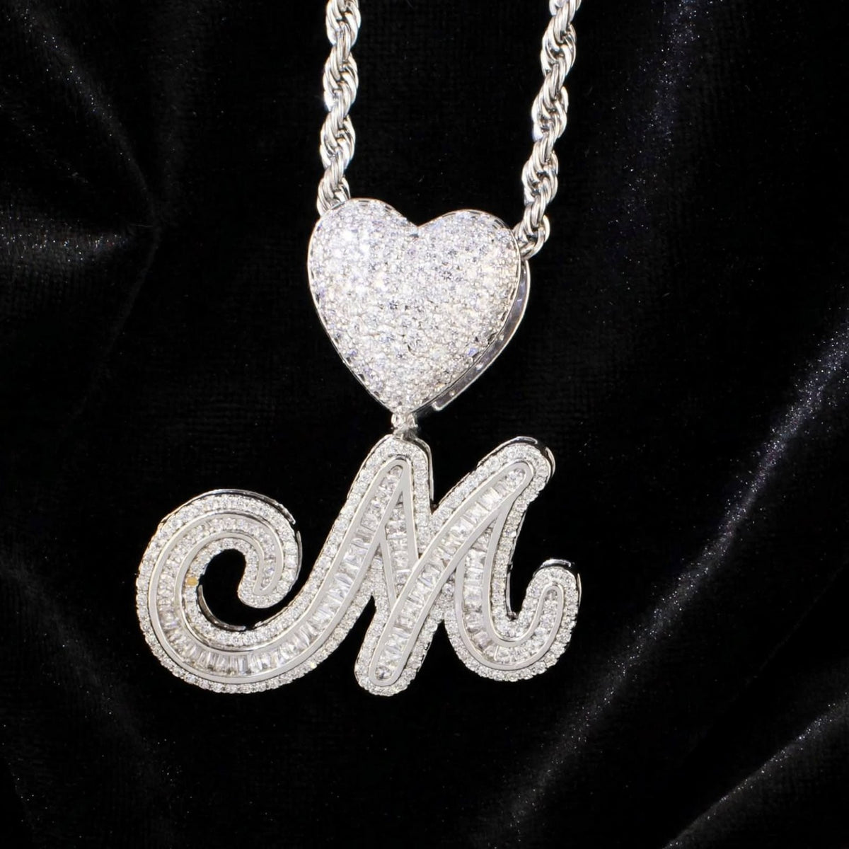 Silver M necklace on black velvet