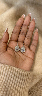 Gold-tone pear-cut moissanite drop earrings displayed on hand