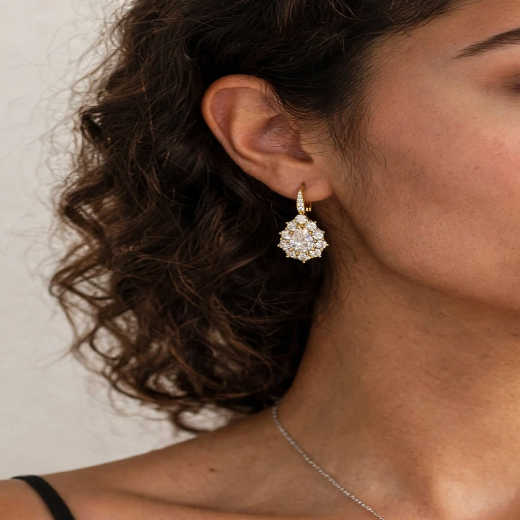 Close-up of gold-tone pear-cut drop earring worn on model