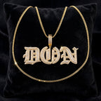 Gold Old English DON custom pendant with chain displayed on black velvet