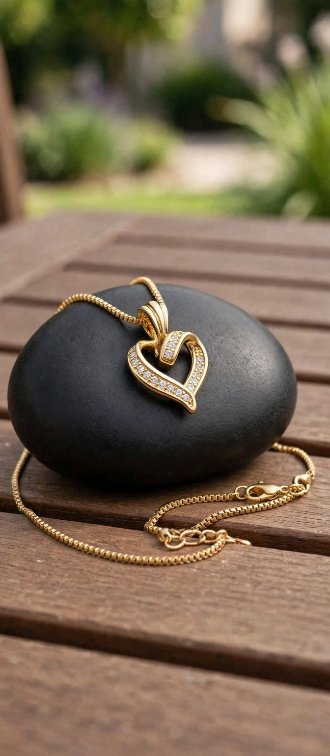 The Golden Embrace open-heart gold-tone necklace resting on black stone