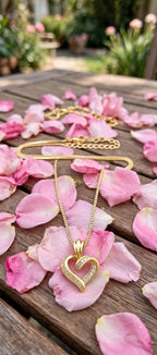 Gold-tone open-heart necklace styled with pink rose petals