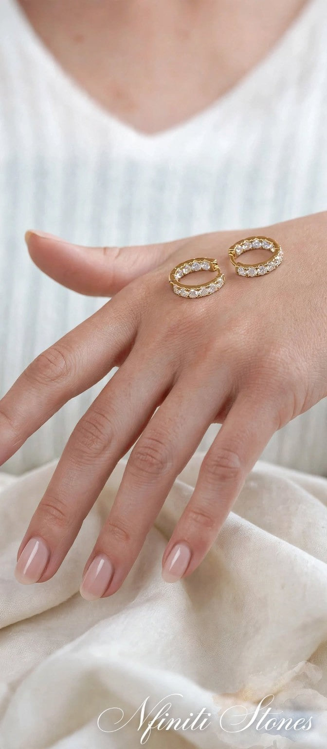 Pair of yellow-finish moissanite hoop earrings on hand